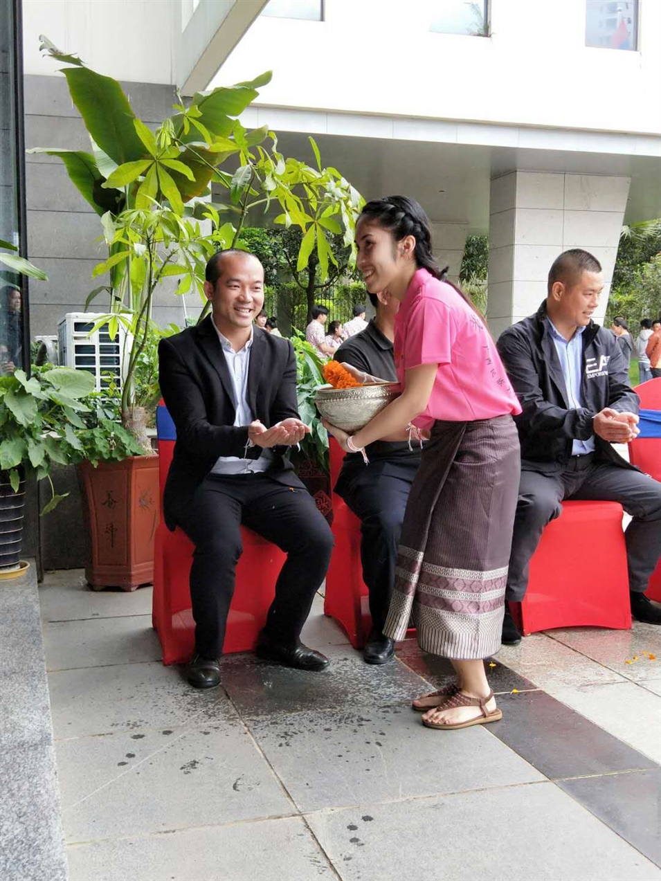 老撾駐廣西留學生代表將浸有花瓣的香水灑客人的手上，表示對嘉賓的美好祝福（圖一）