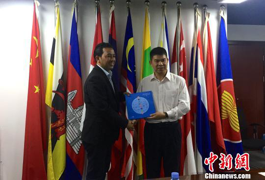 中國—東盟博覽會秘書處副秘書長黃平西（右）與柬埔寨新聞部新聞與傳播總司副總司長春占皮侖（左）互贈禮物。